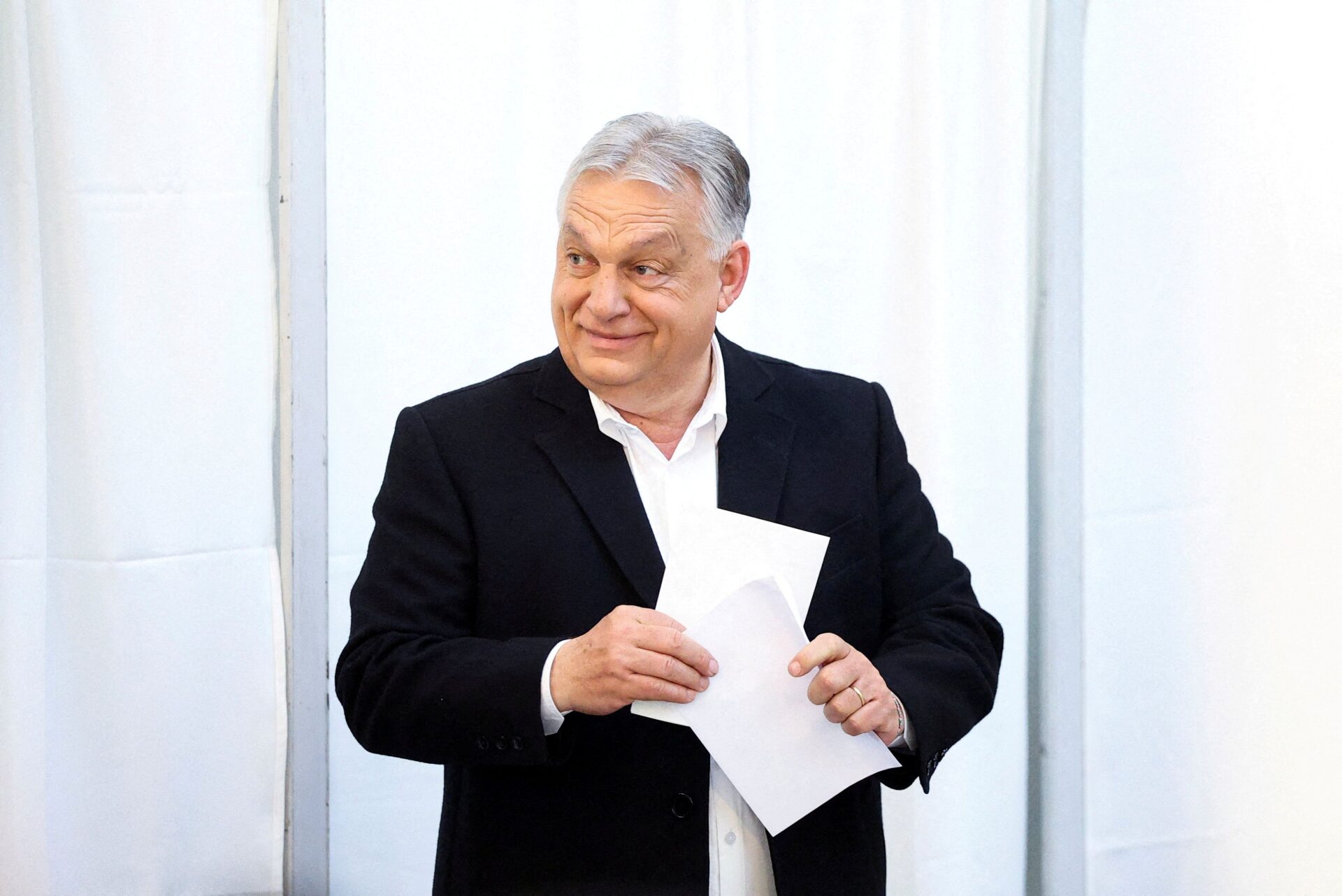 Eleitores húngaros votando em seção eleitoral durante pleito nacional.