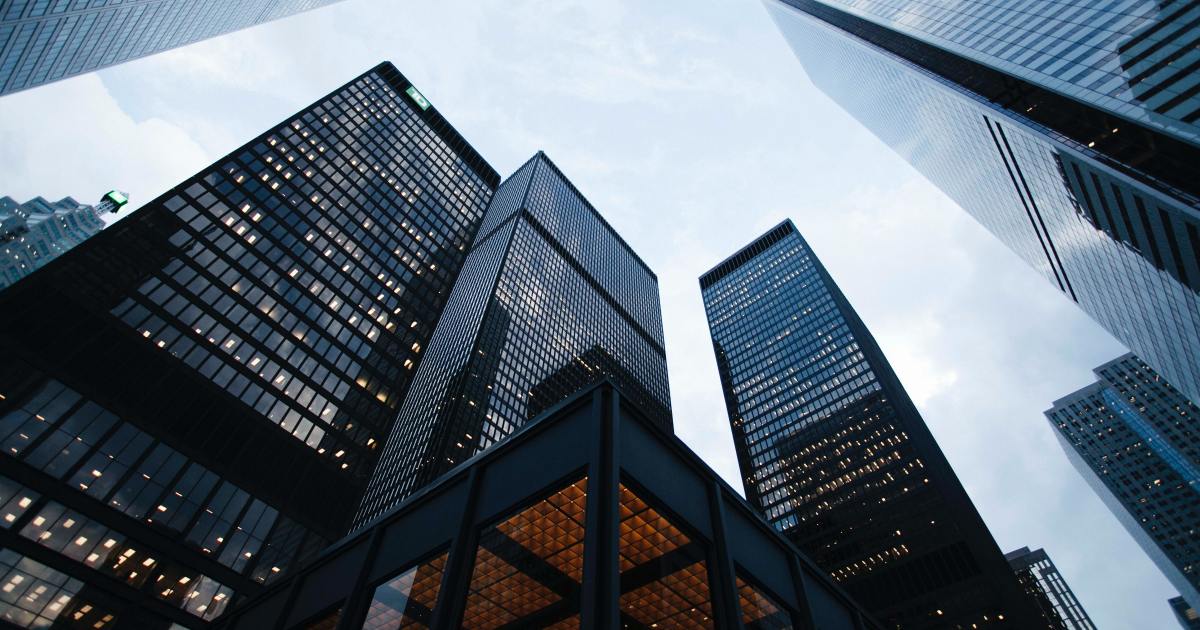 Prédios de alto padrão em centro financeiro representando o setor imobiliário.