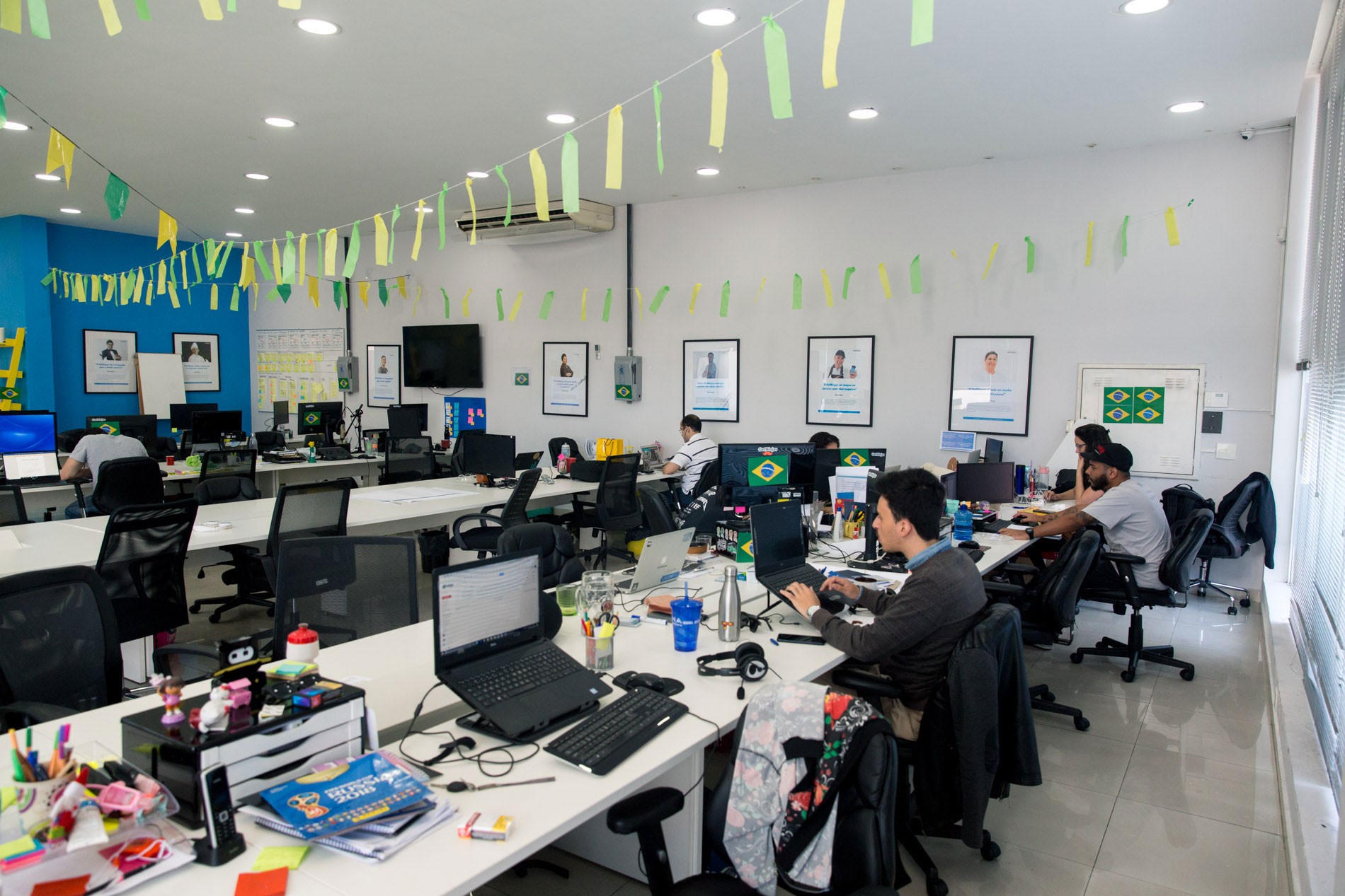 Funcionários da startup GetNinjas acompanham jogo da Copa do Mundo em telão no escritório.